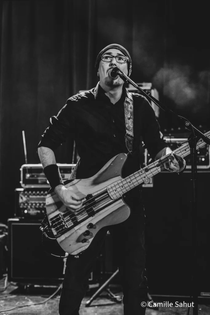 Damien, bassiste de Basket Case, en performance live Damien, bassiste de Basket Case, jouant en live sur scène.