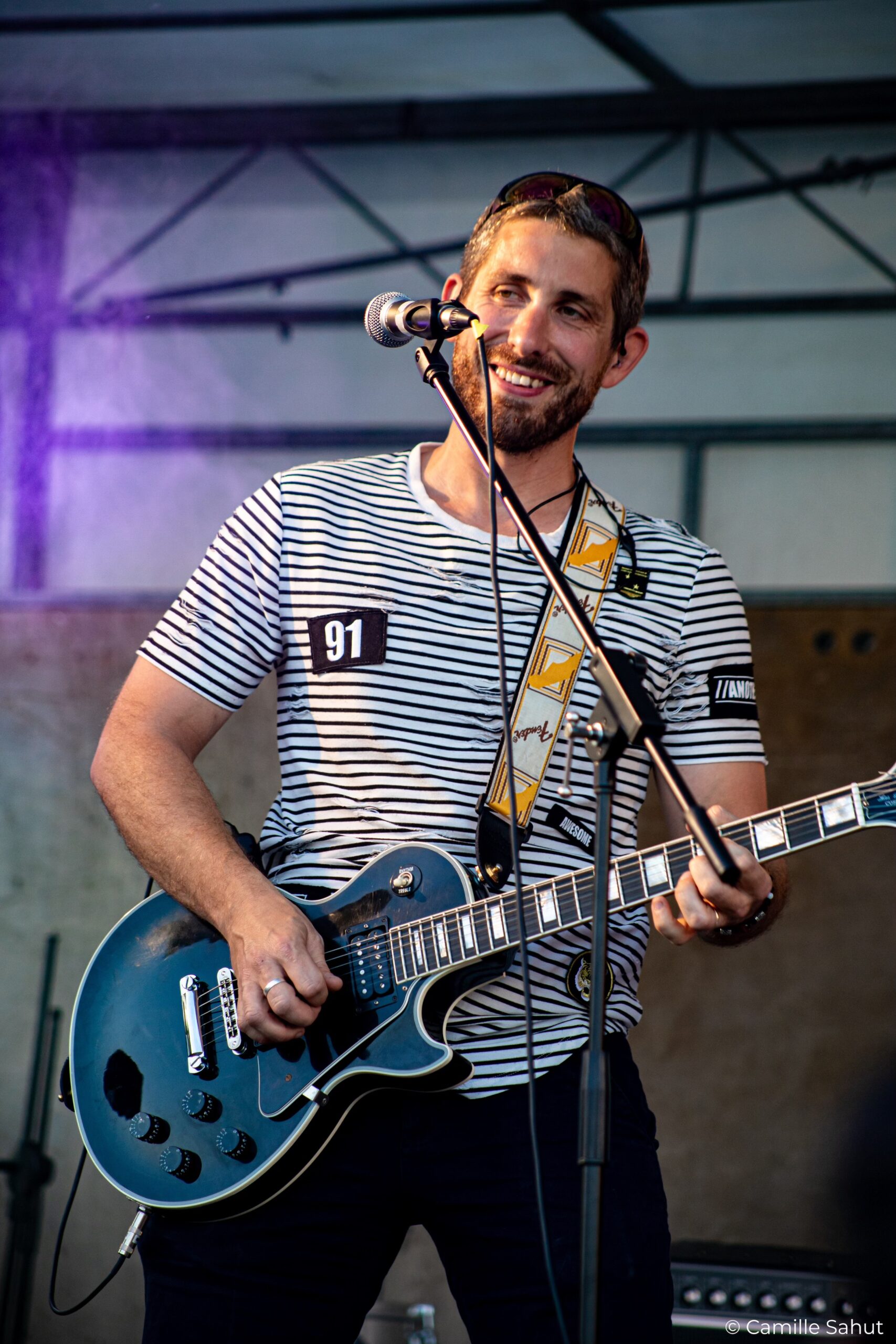Photo de Cédric, le guitariste soliste du groupe Basket Case souriant.